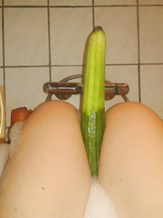 Milf is playing with cucumber in the bathtub