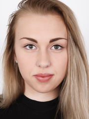 Blond female Adela takes off her raiment whilst holding her face firm