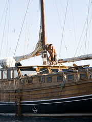 Hawt large titted wench engulfing penis on her knees exposed outdoors on the wharf