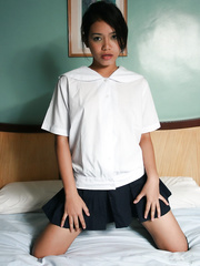 Sexy Oriental legal age teenager schoolgirl sheds her uniform to rub her shaved twat on the couch