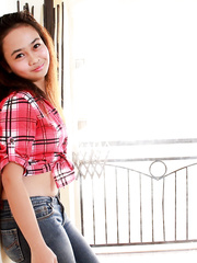 Oriental teenager in blue jeans strips to pose in the exposed for the 1st time