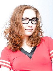 Hawt redhead in glasses & fishnet nylons widens to disclose a curly snatch