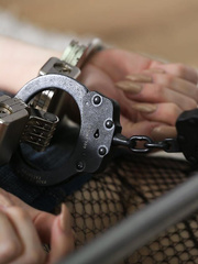 Blindfolded and ballgagged female is placed in cuffs and spreader bar