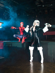 Blond latex attired cosplay enthusiast with large wobblers giving large ramrod a bj