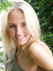 Juvenile blond female Jaime A stripping off raiment to model nude outdoors