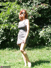 Sexy redhead dilettante Vanessa strips underneath a tree to air her large saggy melons