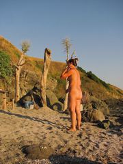 Spying mature woman at the beach early morning covered in mud