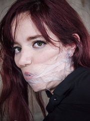 Tattooed villein Ariel Blue in stockings tied spreadeagled and gagged with tape