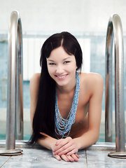 Cute smiley Loreen takes a slim dip in the pool and shows her soaked slit