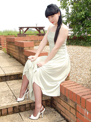 Chic sweetheart flashes her nude muff outside wearing tan nylons and garters