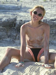 Sexy blonde woman showing body and face playing with herself