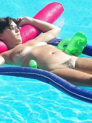 Nude wife for all to see and enjoy relaxing on inflatable in pool