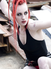 Punk gal with red hair positions stripped in platform boots at industrial web resource