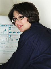 Cute housewife Carlita Johnson undresses in the laundry room to pose in socks