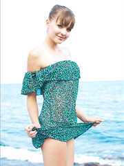 Blue eyed legal age teenager slides off her suit by the ocean to play exposed on the rocks