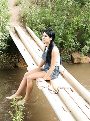 Black haired beauty and her paramour fuck on a wooden bridge that spans a stream