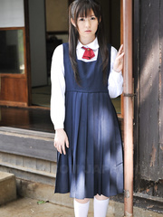 Delightsome Japanese chick posing in her cute school outfit in the garden