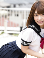 Cute Oriental schoolgirl does a hot stripteases and exposes her curly slit