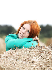 Natural redhead Amber A positions her undressed legal age teenager body on round bale of hay