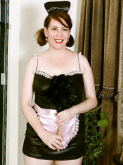 Aged lady Caitlin Moore removes maid uniform to model exposed in nylons