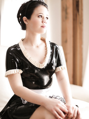 French maid Yhivi sluggishly slides off her uniform in front of wide open window