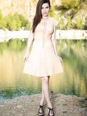 Pretty erotic model Serena posing in nature's garb & widening hairless snatch by the lake
