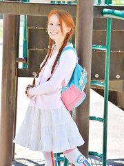 Youthful redhead in pigtails flashes love tunnel at the playground & toys in socks