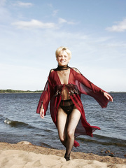 thirty plus blond shows her bald snatch in sheer attire on a secluded beach