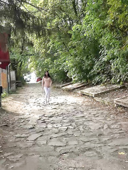 Black haired gal Dee pulls down her white leggings for quick pee behind bushes