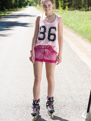 Youthful blond angel Faina receives in nature's garb in centre of road wearing roller blades