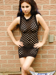 Small legal age teenager with a wild look to her removes mesh suit to pose bare outdoors