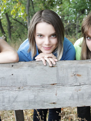 3 juvenile looking angels receives bare on a wooden bench in the countryside