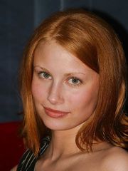 Natural redhead Anya removes red belt to model exposed on a red bed