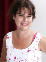 Sexually Excited aged woman removes her flower suit to toy her curly beaver on the ottoman