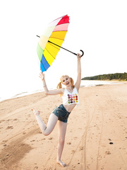 Youthful looking blond legal age teenager Candy fingers her vagina on a desolate beach