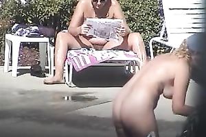 Ample hairy mommy rubs her stripped body with sunscreen by the pool