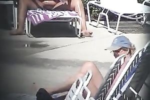 Ample hairy mommy rubs her stripped body with sunscreen by the pool