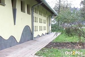 Brunette in fur jacket and dark pants plan to pee right outdoors
