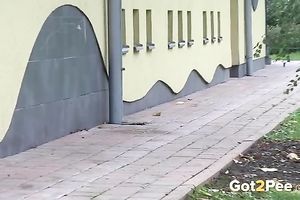 Brunette in fur jacket and dark pants plan to pee right outdoors