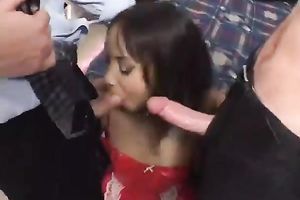 Leggy Asian wench in red latex sex costume sucks 2 white dongs at one time