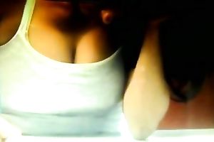 A breasty brunette playgirl on the reception desk has her bra buddies falling out of her top