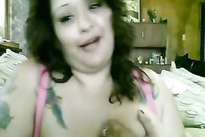 Tattooed bosomy brunette hair smiles during the time that masturbating