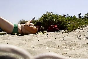 Topless woman with massive bazookas caught sunbathing on a naked beach
