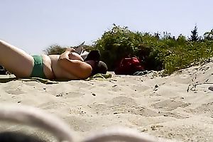 Topless woman with massive bazookas caught sunbathing on a naked beach