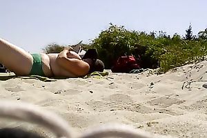 Topless woman with massive bazookas caught sunbathing on a naked beach