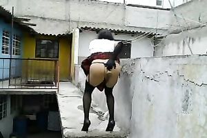 Dirty lady-boy in nylons and small belts masturbates on a roof