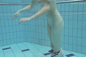 Curvy pale skin redhead chick in the water swims undressed