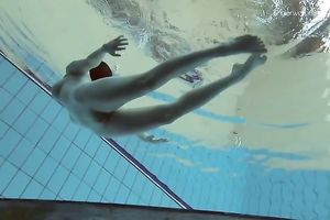 Curvy pale skin redhead chick in the water swims undressed