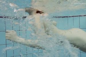 Curvy pale skin redhead chick in the water swims undressed