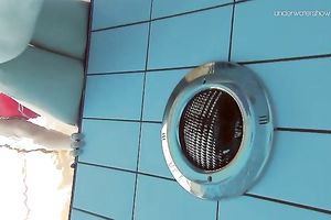 Curvy pale skin redhead chick in the water swims undressed